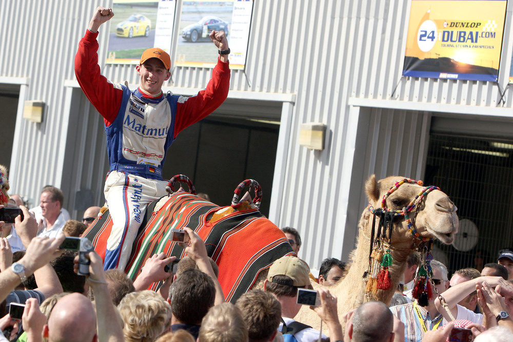 Marco Holzer riding a camel in celebration of winning the Dubai 24