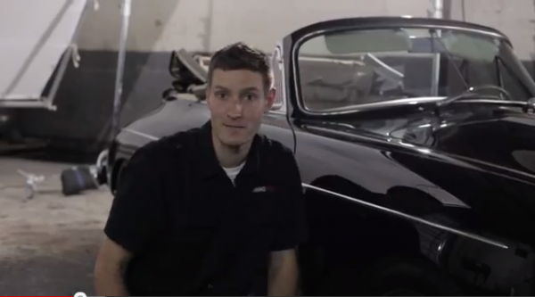 Larry from AMMOnyc sitting next to a Porsche 356