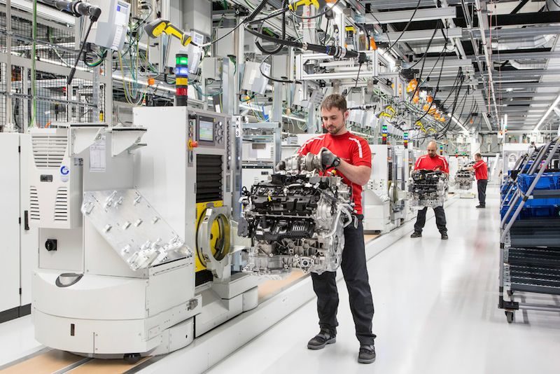 Technicians assembling engine at Porsche v-8 factory
