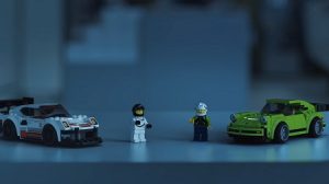 two lego action figures and their Porsche speed champion rides